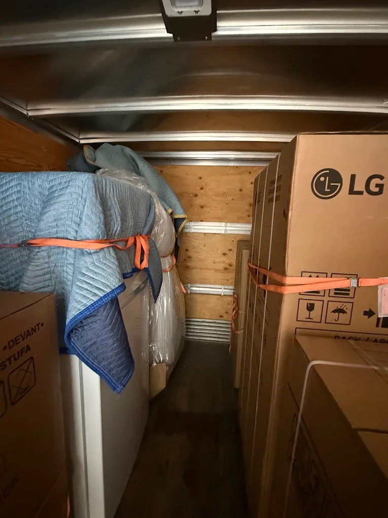 Boxed appliances and household furniture in a real delivery load.
