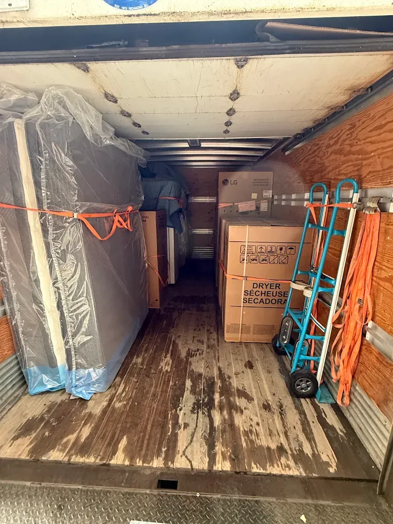 Protected household furniture and boxed items loaded in the truck.