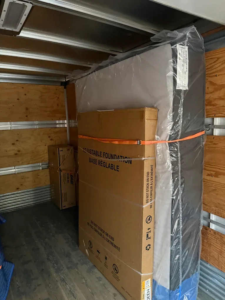 A mattress and boxed items in the moving truck.