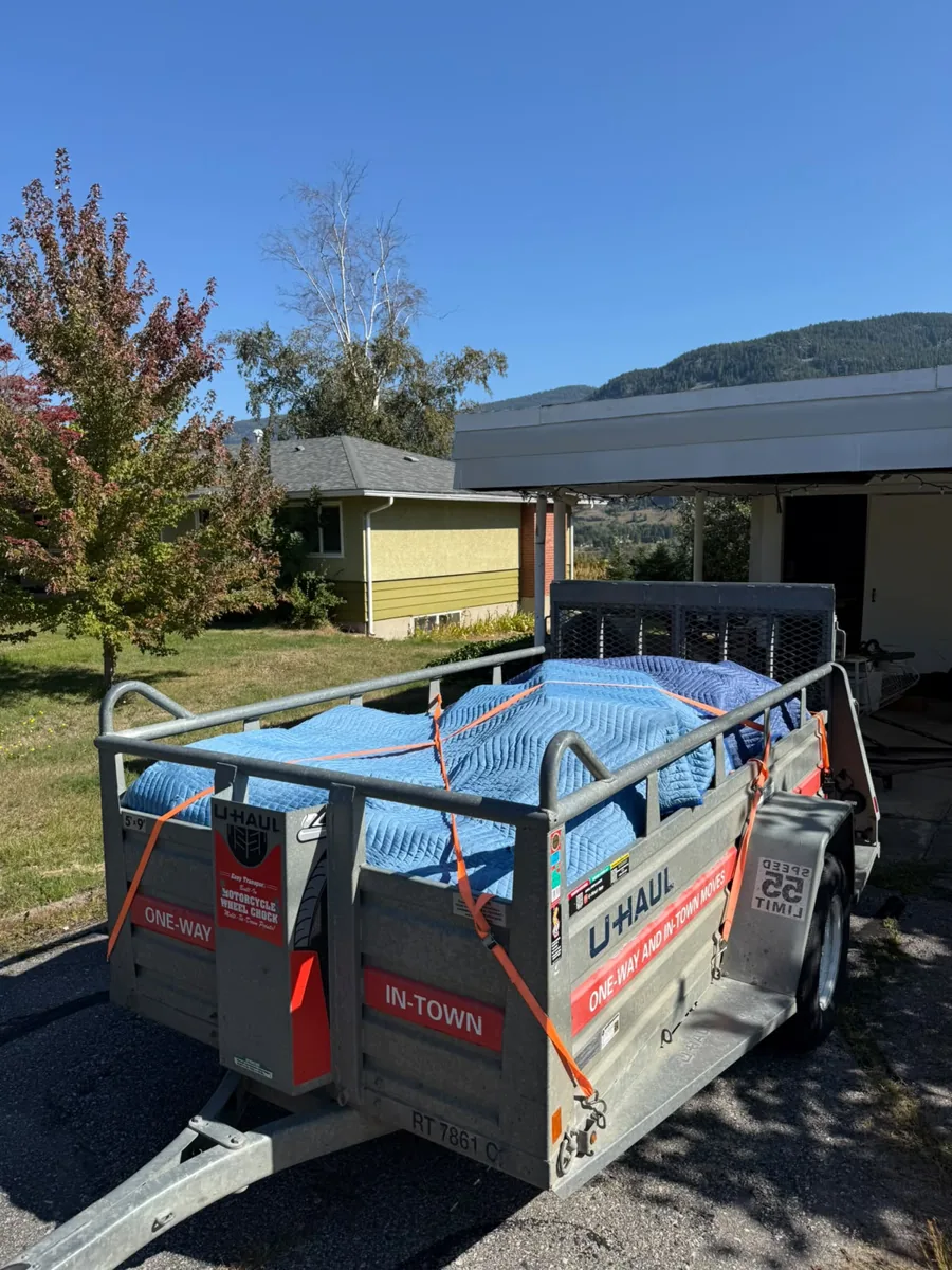 Moving load covered with blue blankets and held with orange straps