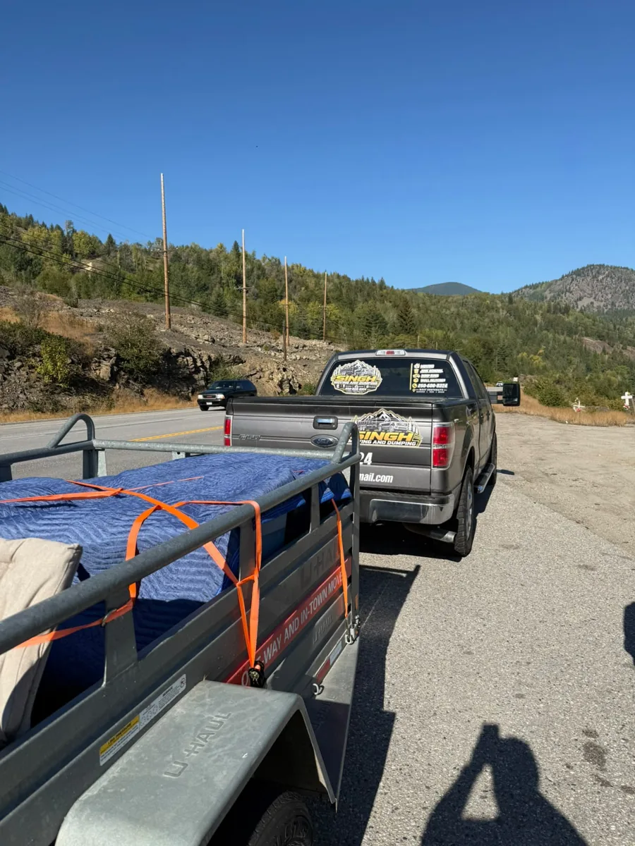 Singh truck and trailer with blanket-covered items and orange straps
