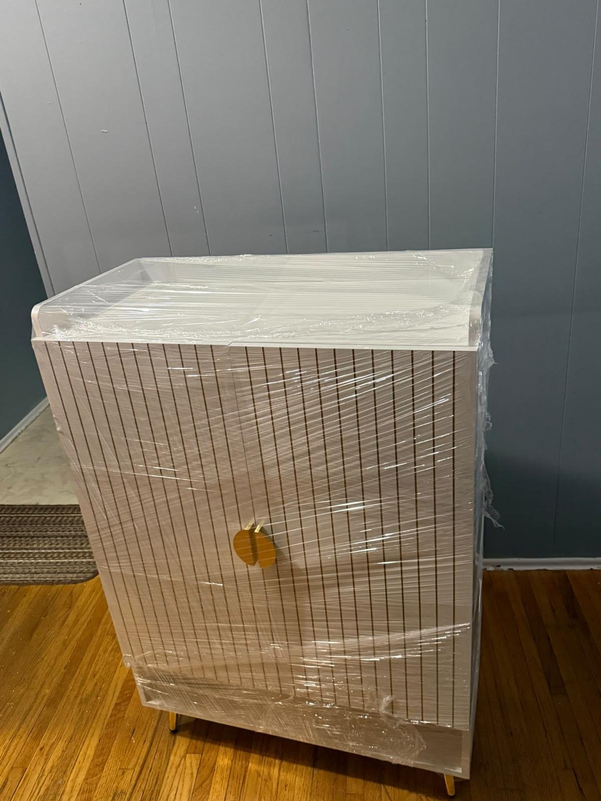 A tall cabinet wrapped in clear protective film before a household move.