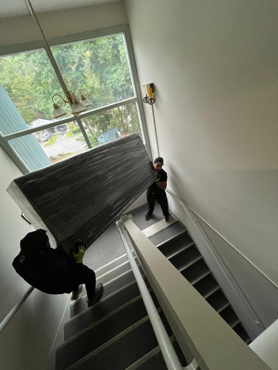 Moving a Sofa Down Apartment Stairs with Protective Wrapping